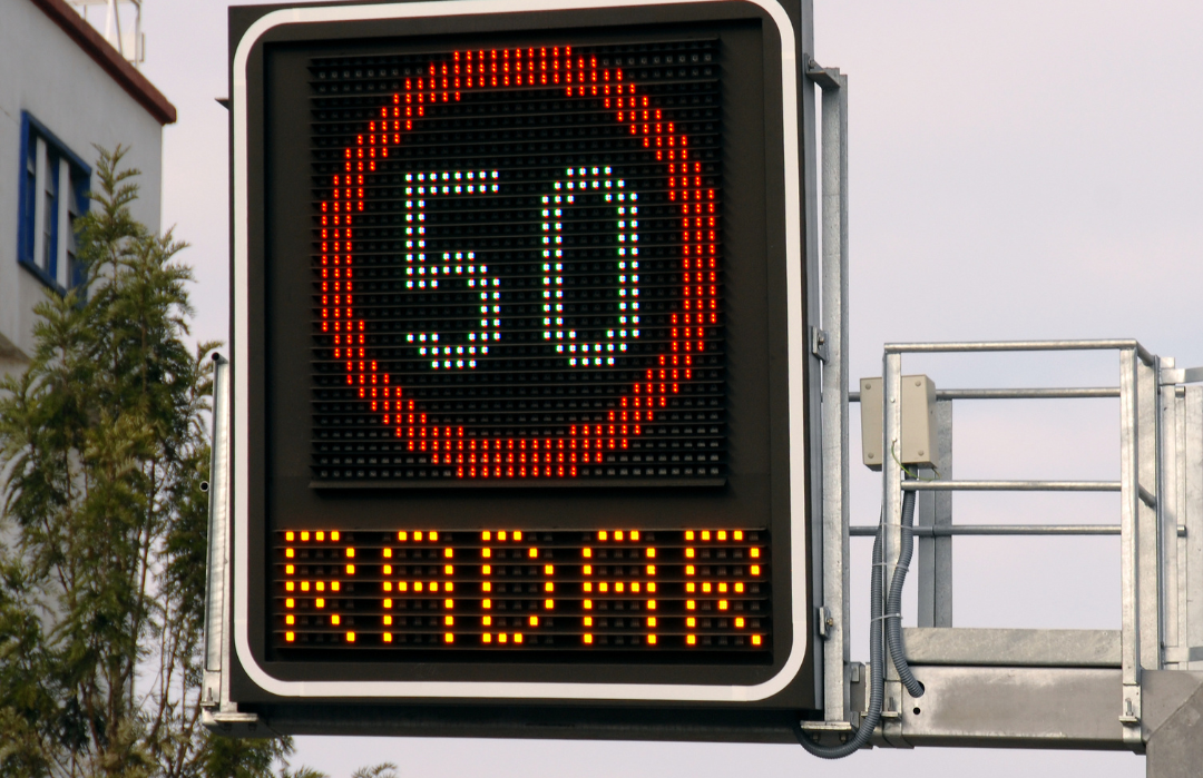 A imagem mostra uma placa luminosa que indica um limite de 50km/h e que há fiscalização com radar de velocidade.