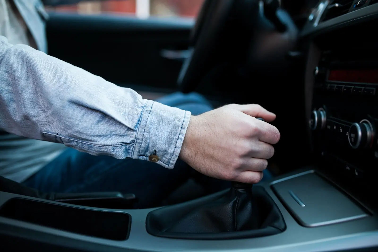 Close-up de um motorista trocando a marcha do seu carro com facilidade com ajuda do sistema de rotação.