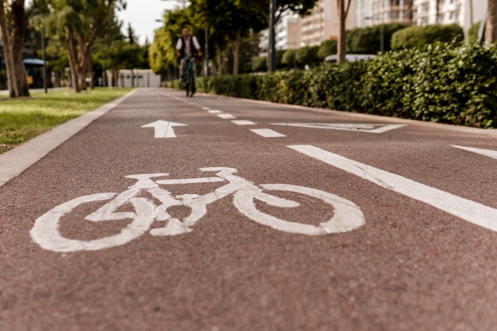 Close-up de uma ciclovia mostra a imagem de uma bicicleta pintada no asfalto, simbolizando a importância da mobilidade urbana sustentável.
