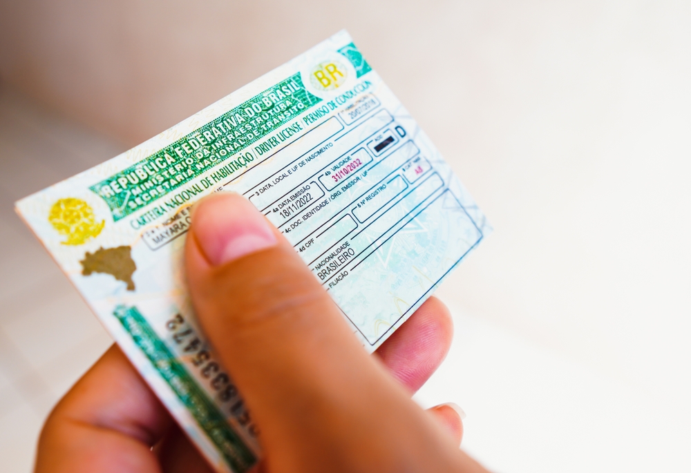 Close-up de uma pessoa segurando a carteira nacional de habilitação do Brasil.