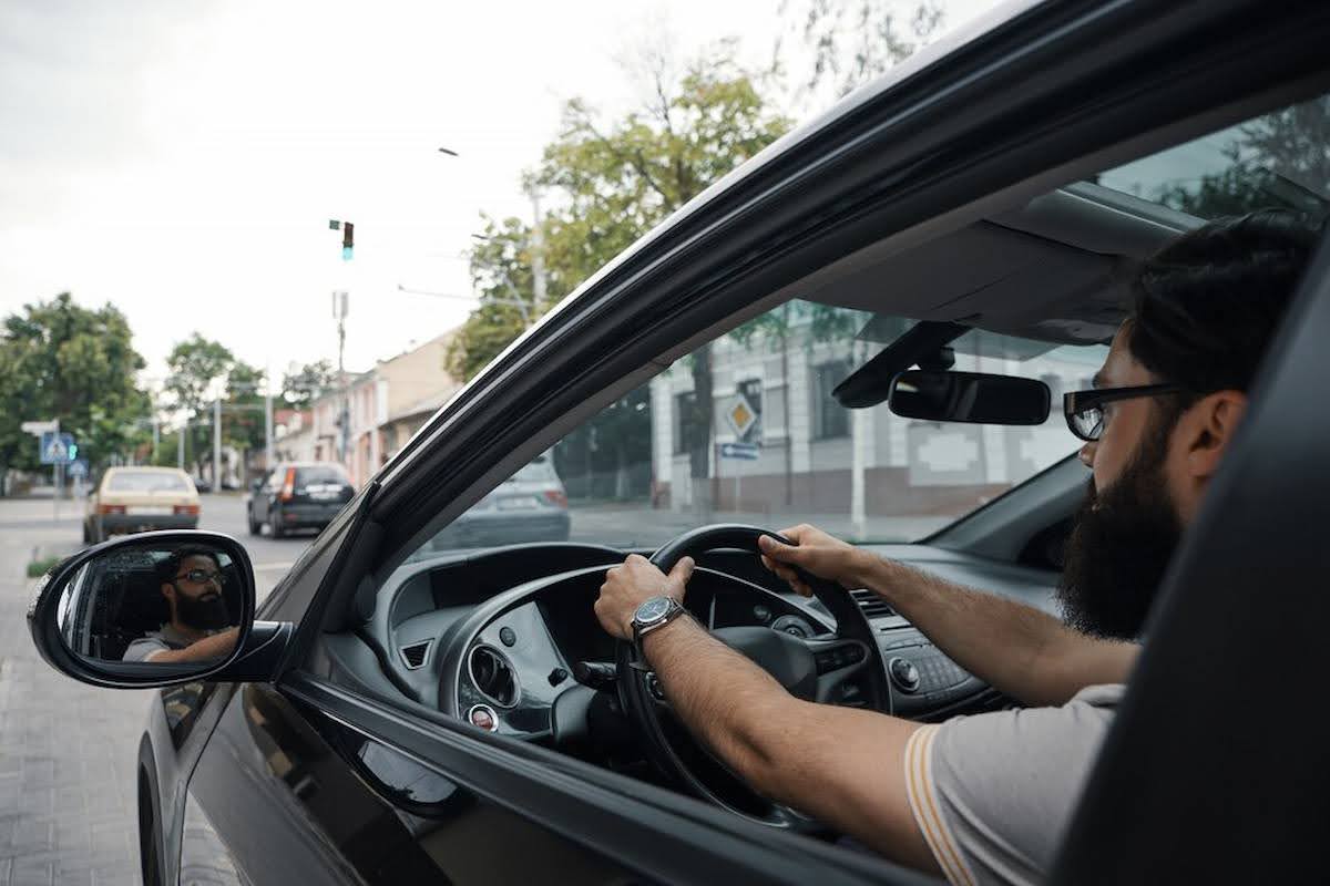 Imagem mostra um homem dirigindo um carro falando sobre a renovação da cnh.