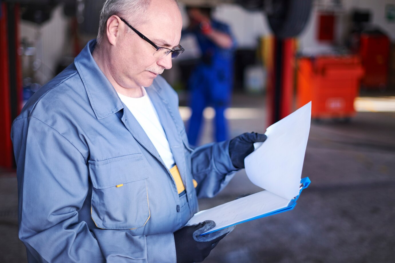 Homem mais velho segurando uma prancheta e revisando documentos em um ambiente industrial. Representando o que é vistoria cautelar.