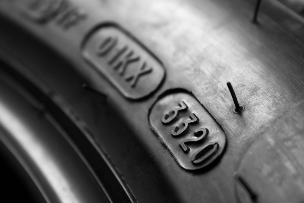 Imagem em close-up da data de fabricação de um pneu desgastado.