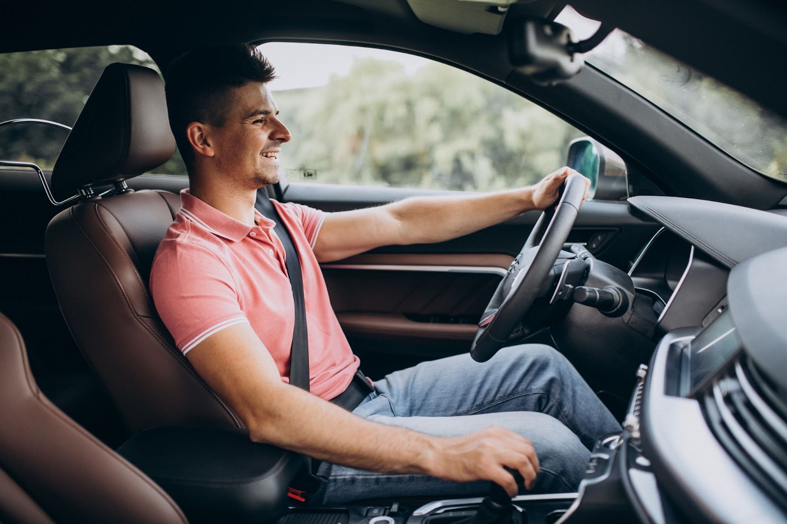 Homem feliz dirigindo seu carro após realizar a manutenção preventiva veicular.