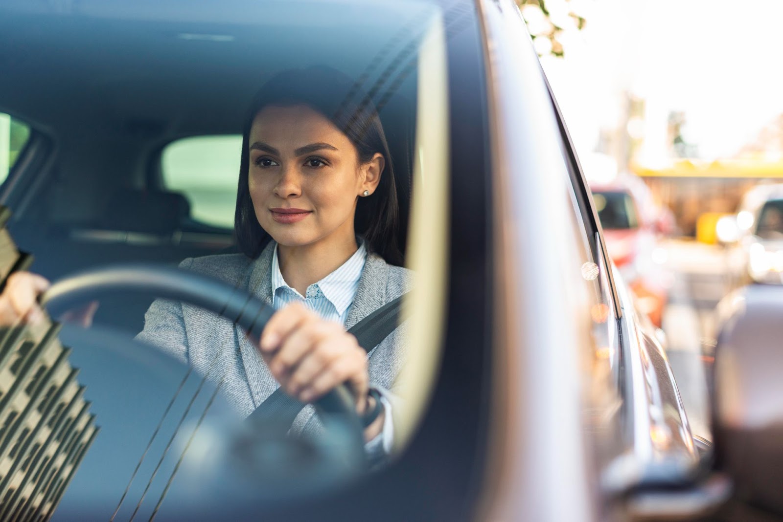 Mulher sorridente dirigindo um carro, mostrando como perder o medo de dirigir.