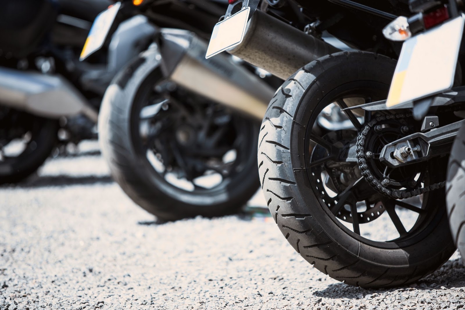 Close-up das rodas de motocicletas estacionadas umas ao lado da outra durante o dia.