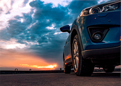Blue Sports Sedan under Cloudy Sunset