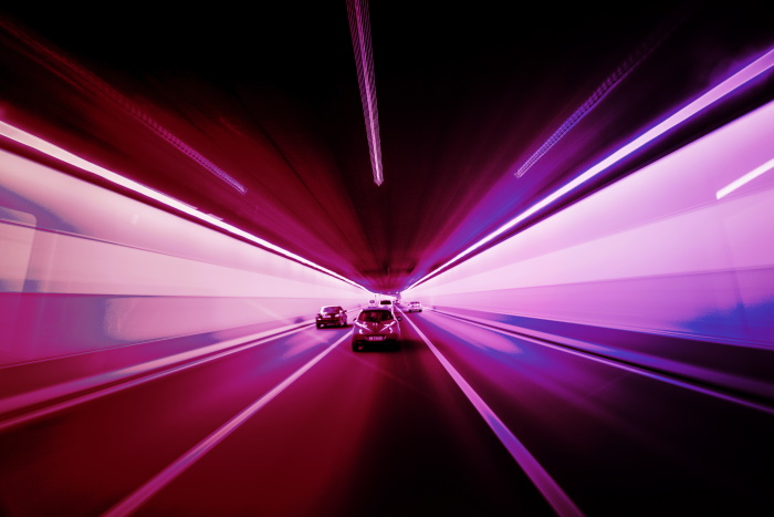 Cars Driving through Distorted Lit Tunnel
