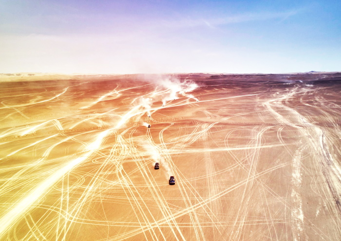 Cars Making Tracking in Sandy Desert