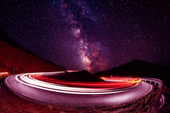 Distorted Car Lights around Highway Bend beneath Starry Night Sky