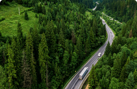 Trucks and Cars on the Open Road with Trees Adjacent