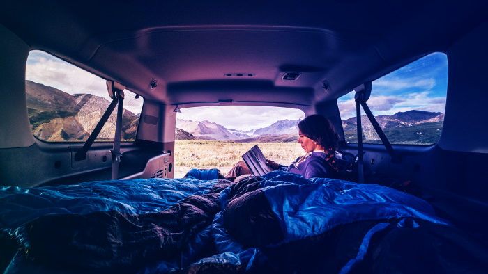 woman reading book in car