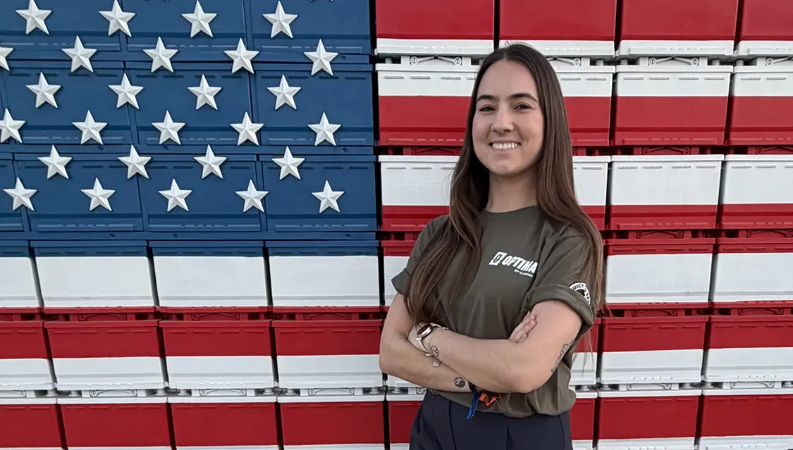 Rachael Samalis in front of American Flag of batteries