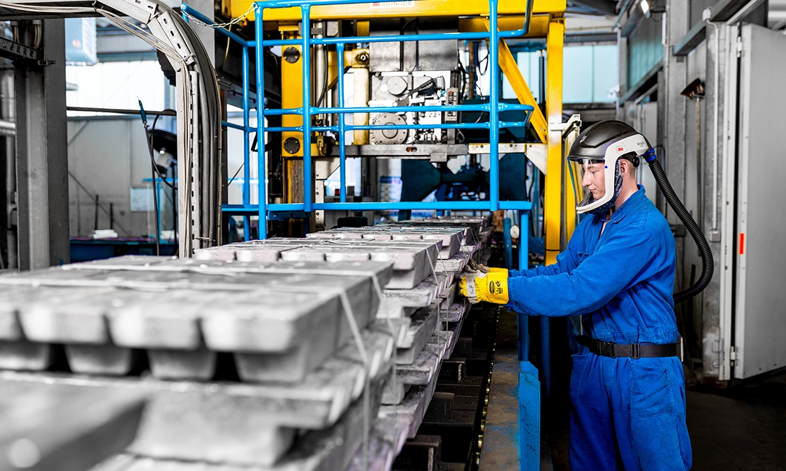 Employee loading stacks of lead for production