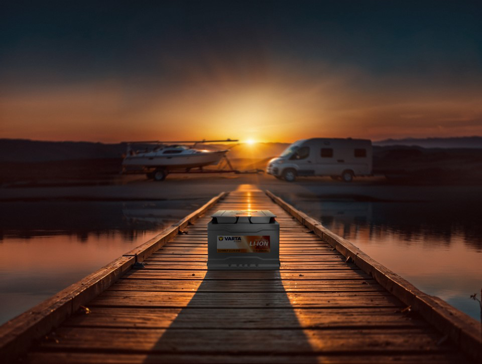 varta lithium-ion battery on dock with rv and boat in background